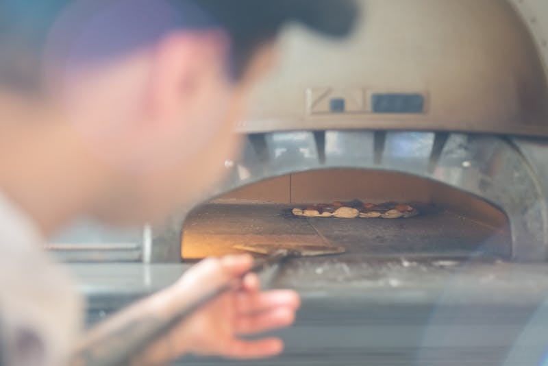 Anthony's coal fired pizza catering team serving guests at an event